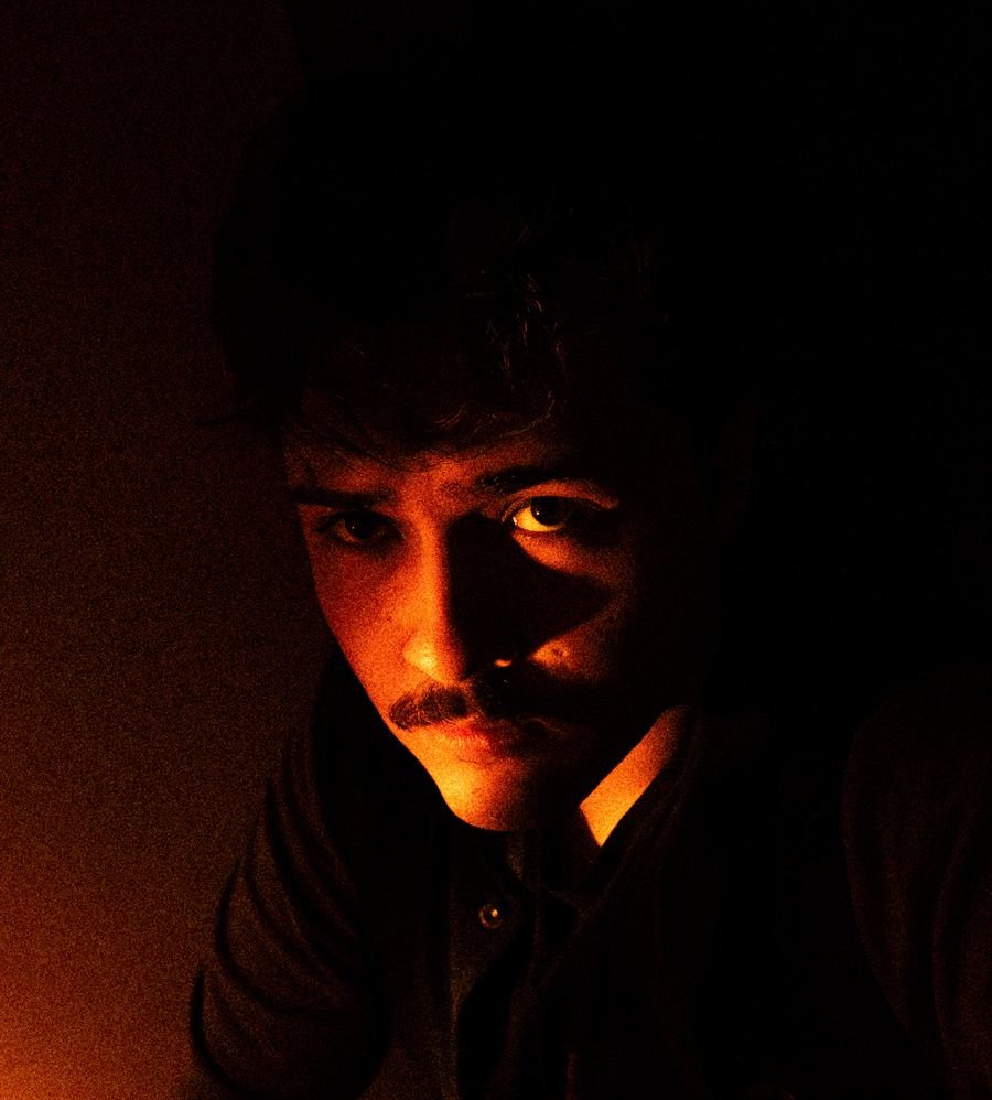 Paulo Ricardo iluminado por uma luz laranja no escuro